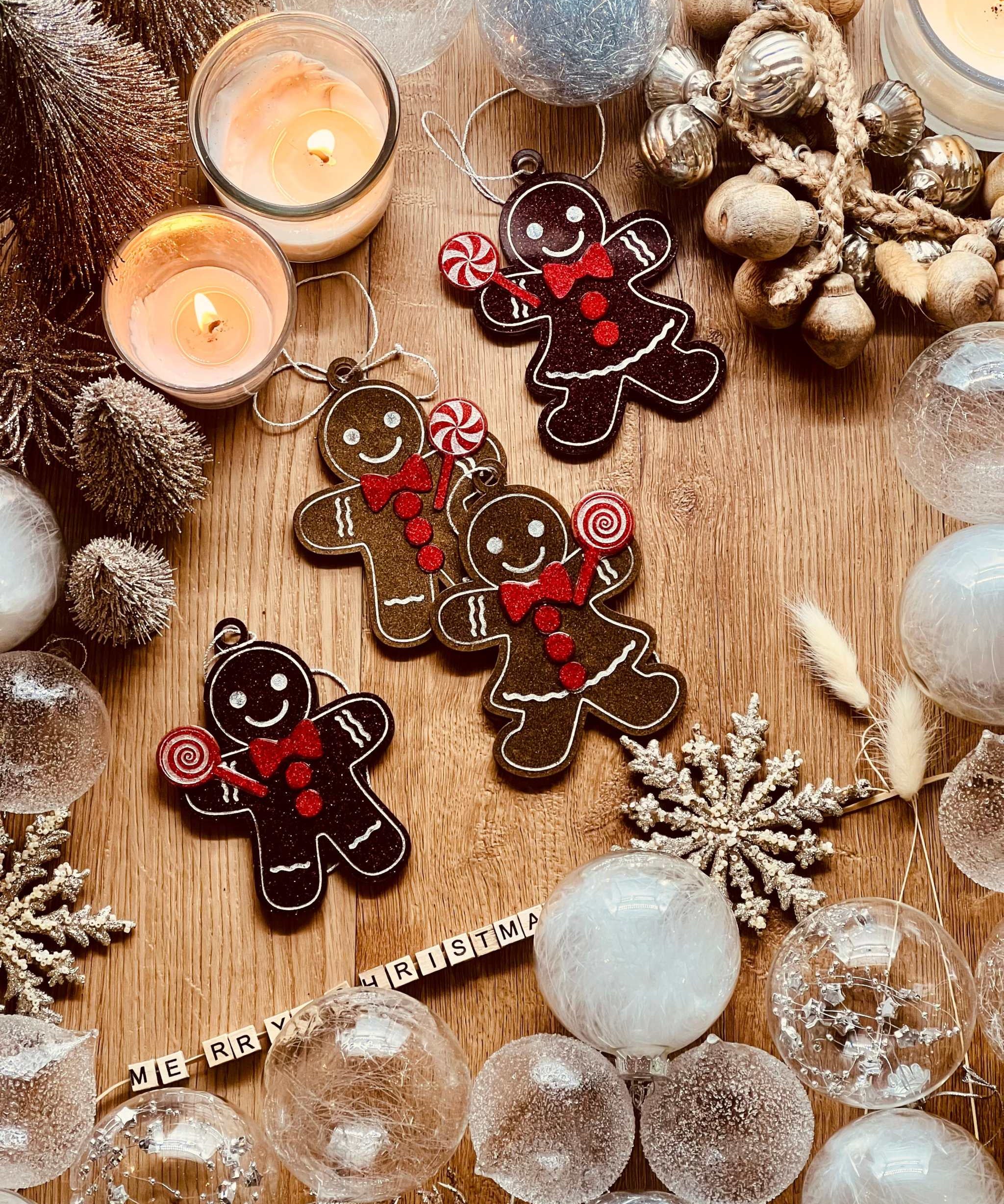 Handmade resin gingerbread men Christmas tree ornaments in brown and red tones.