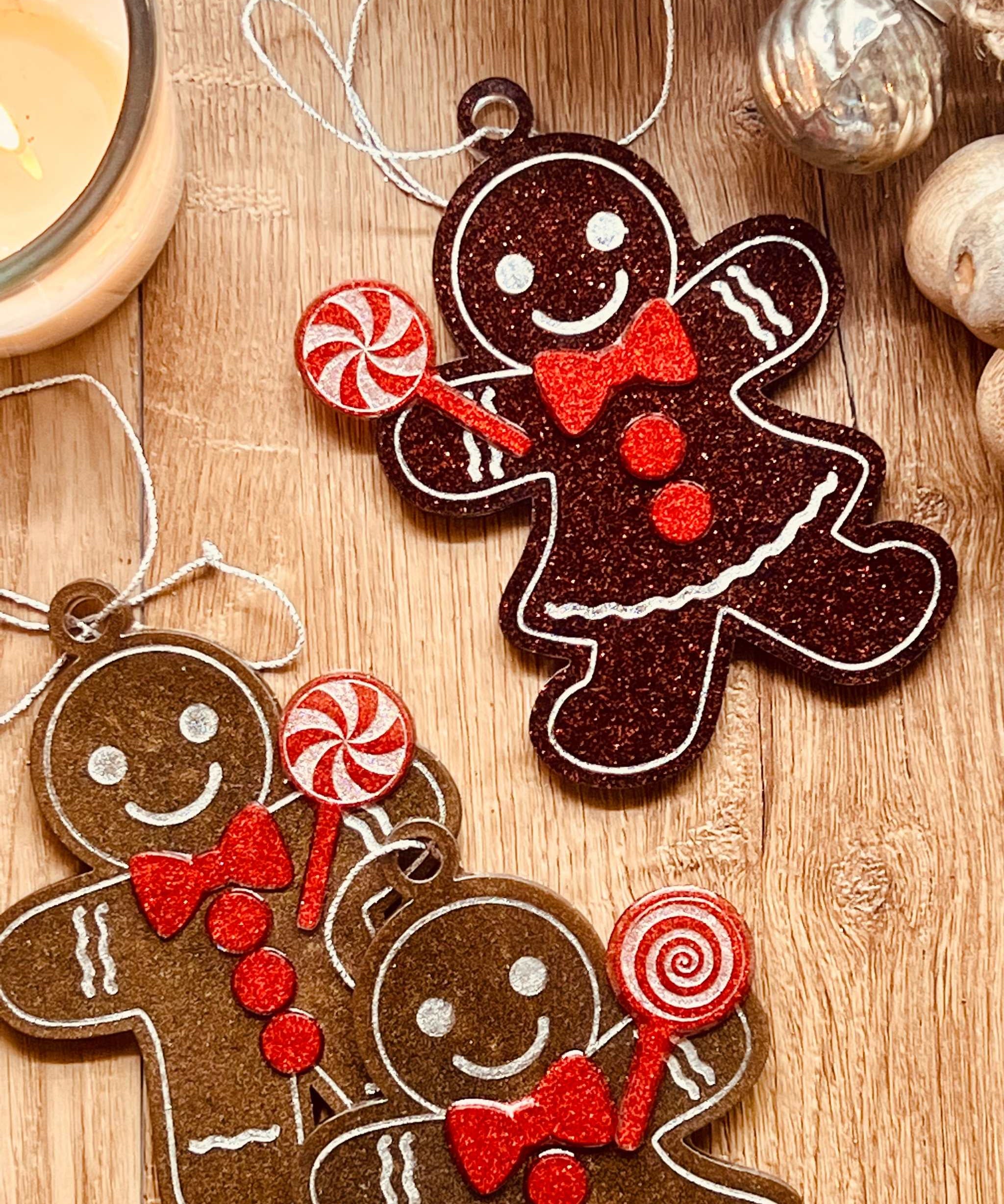Handmade resin gingerbread men Christmas tree ornaments in brown and red tones.