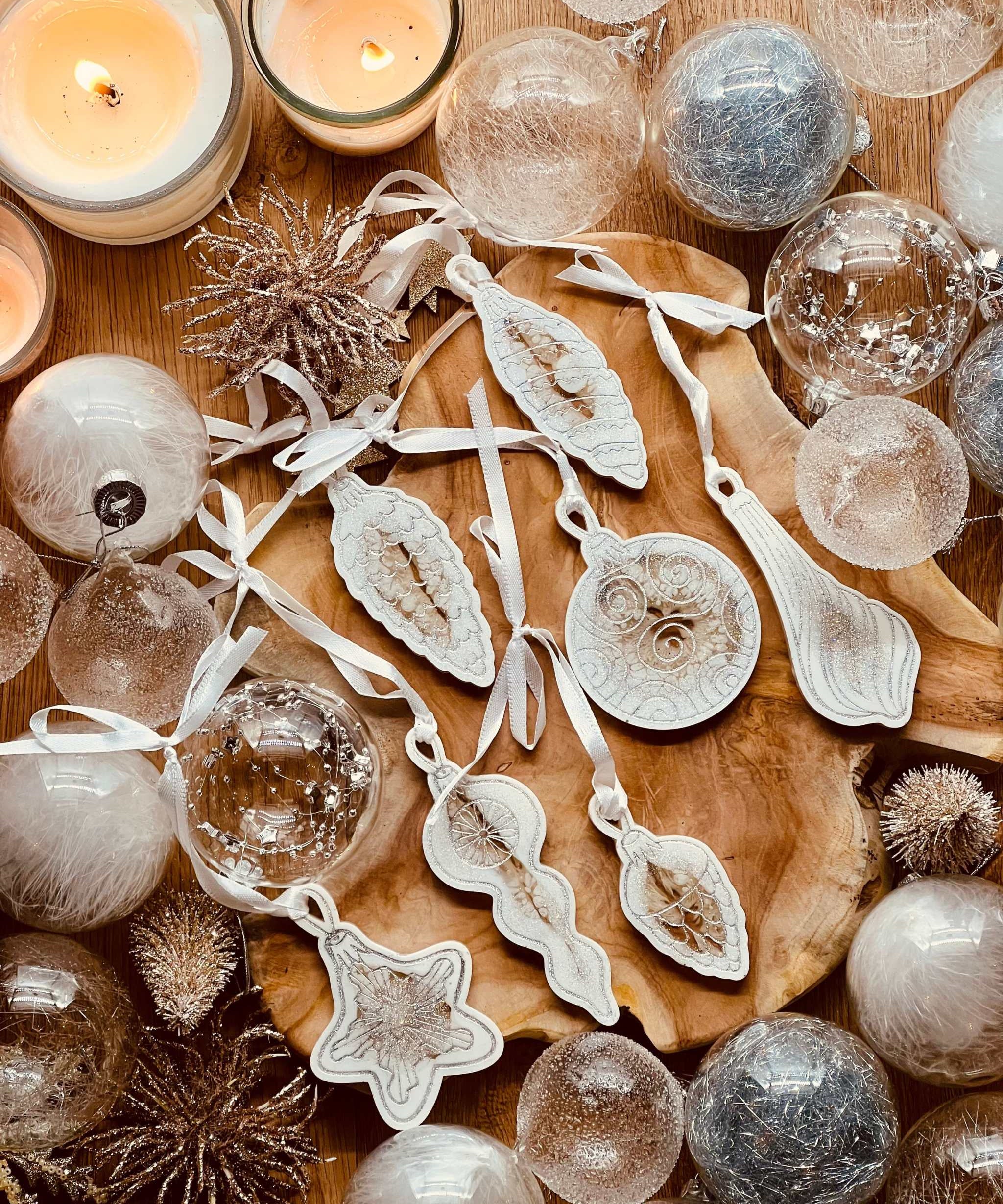 Handmade white and silver resin Christmas tree ornaments set of 7 displayed on a wooden surface.