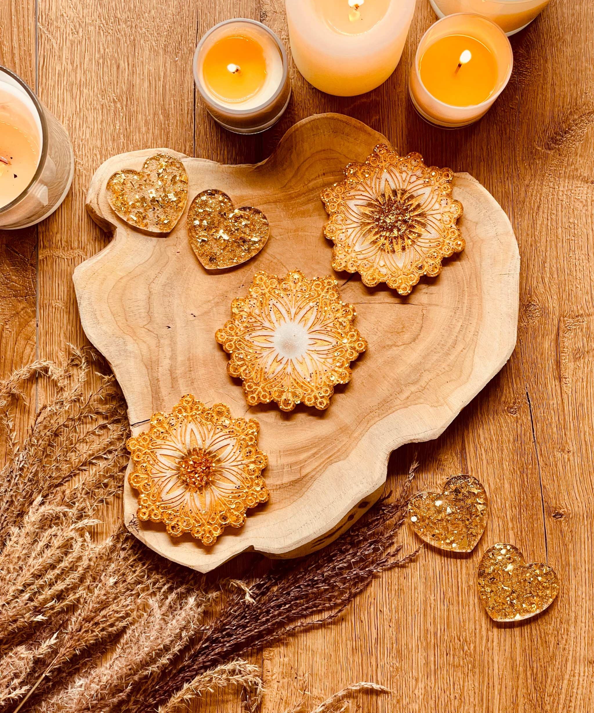 Three gold and white resin coasters on wooden table for Weihnachtliche Deko.