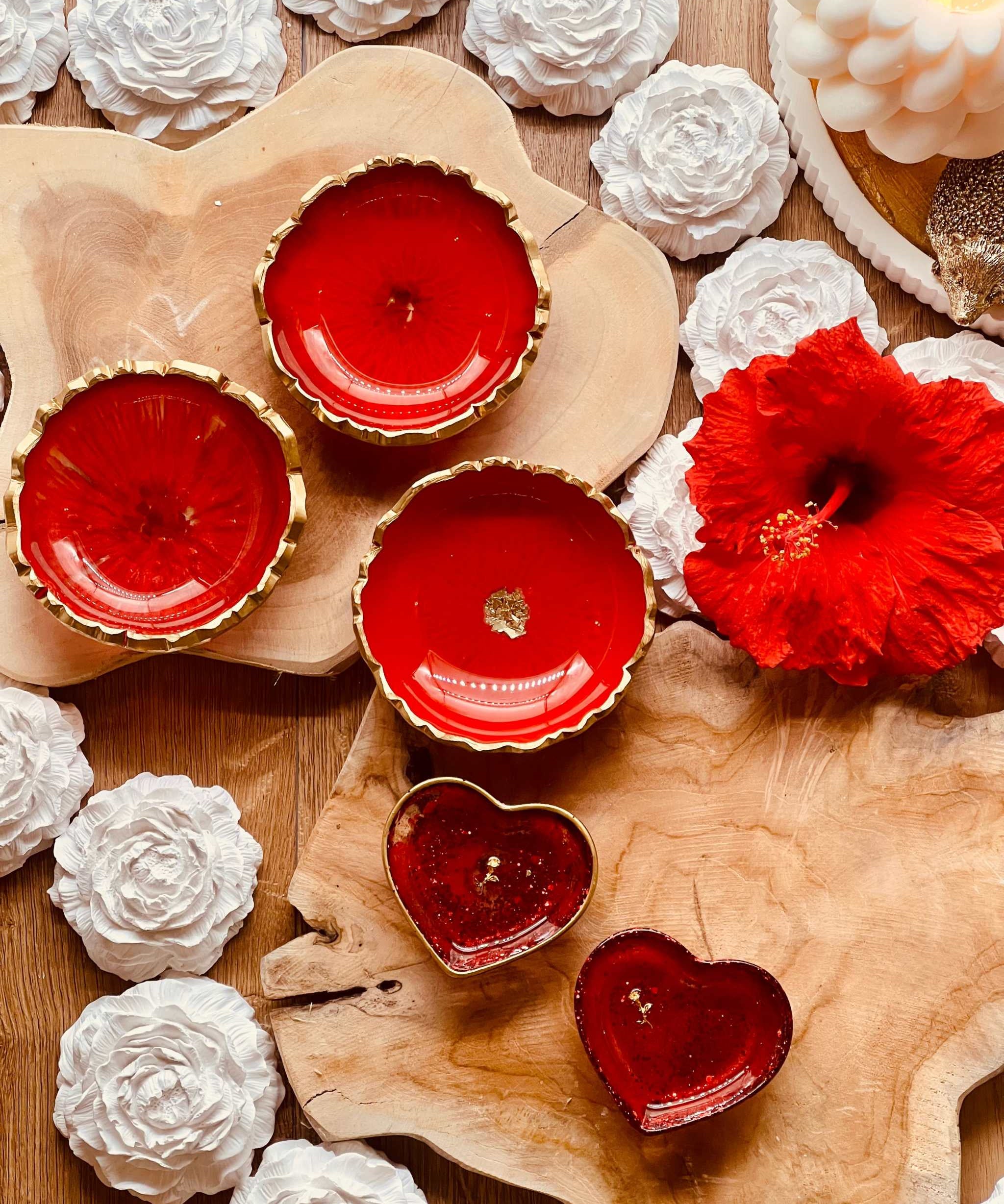 rote handgemachte Schmuckschalen aus Resin mit goldenen Details in Herz- und Rundform auf Holzunterlage