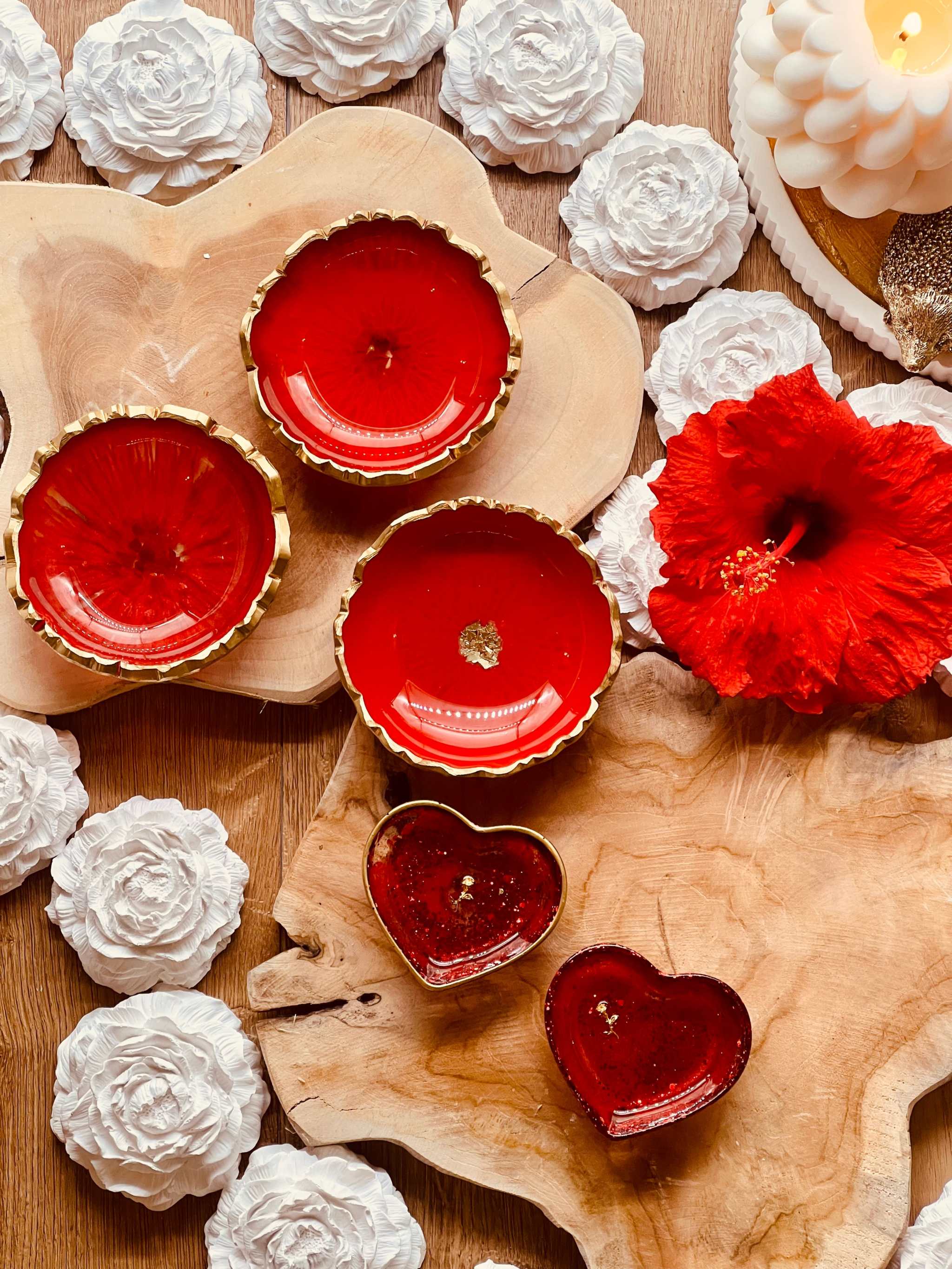 rote handgemachte Schmuckschalen aus Resin mit goldenen Details in Herz- und Rundform auf Holzunterlage