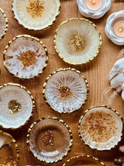 Handgefertigte weiße Schmuckschalen aus Resin mit goldenen Details auf Holztisch dekorativ angeordnet