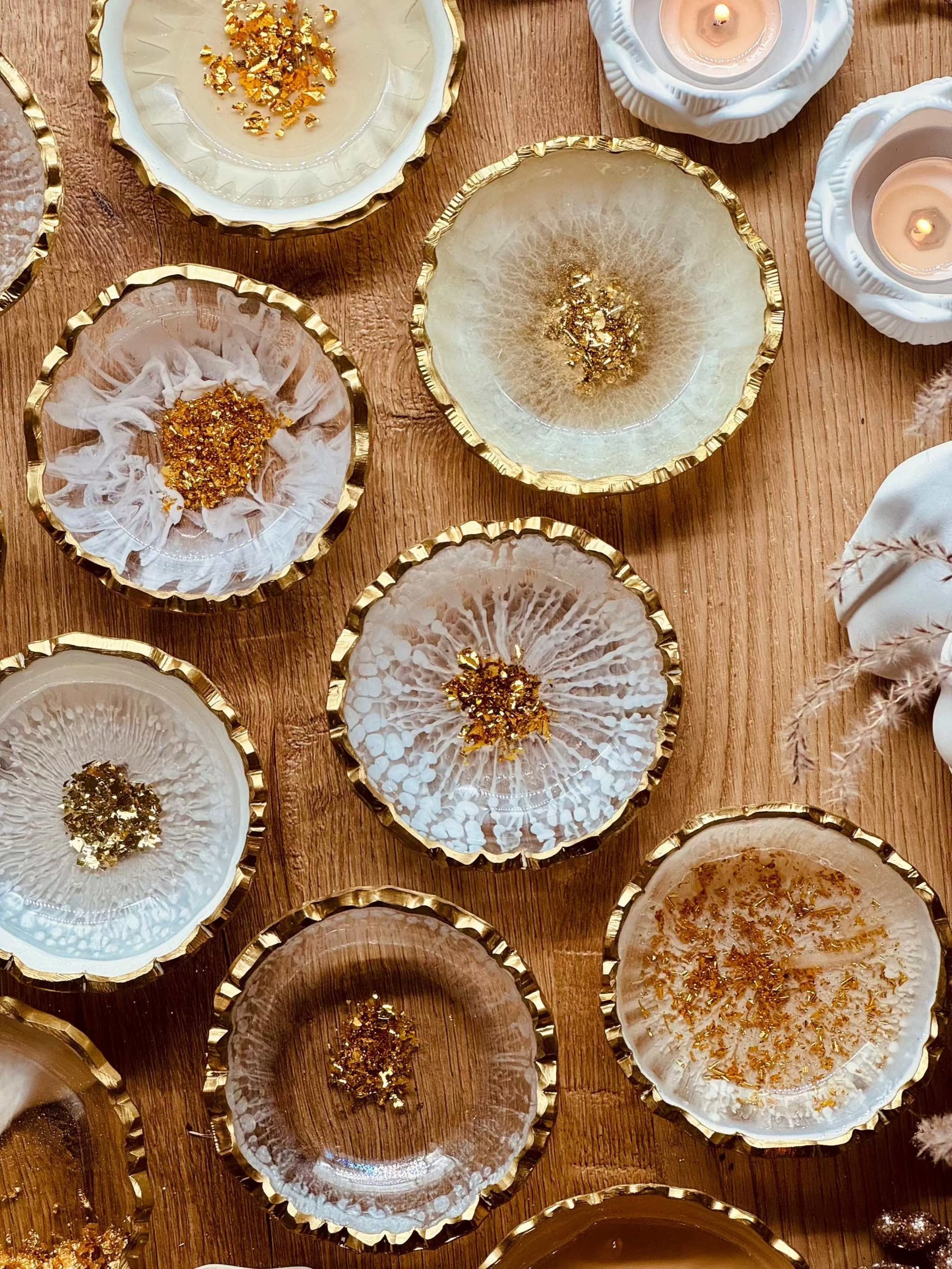 Handgefertigte weiße Schmuckschalen aus Resin mit goldenen Details auf Holztisch dekorativ angeordnet