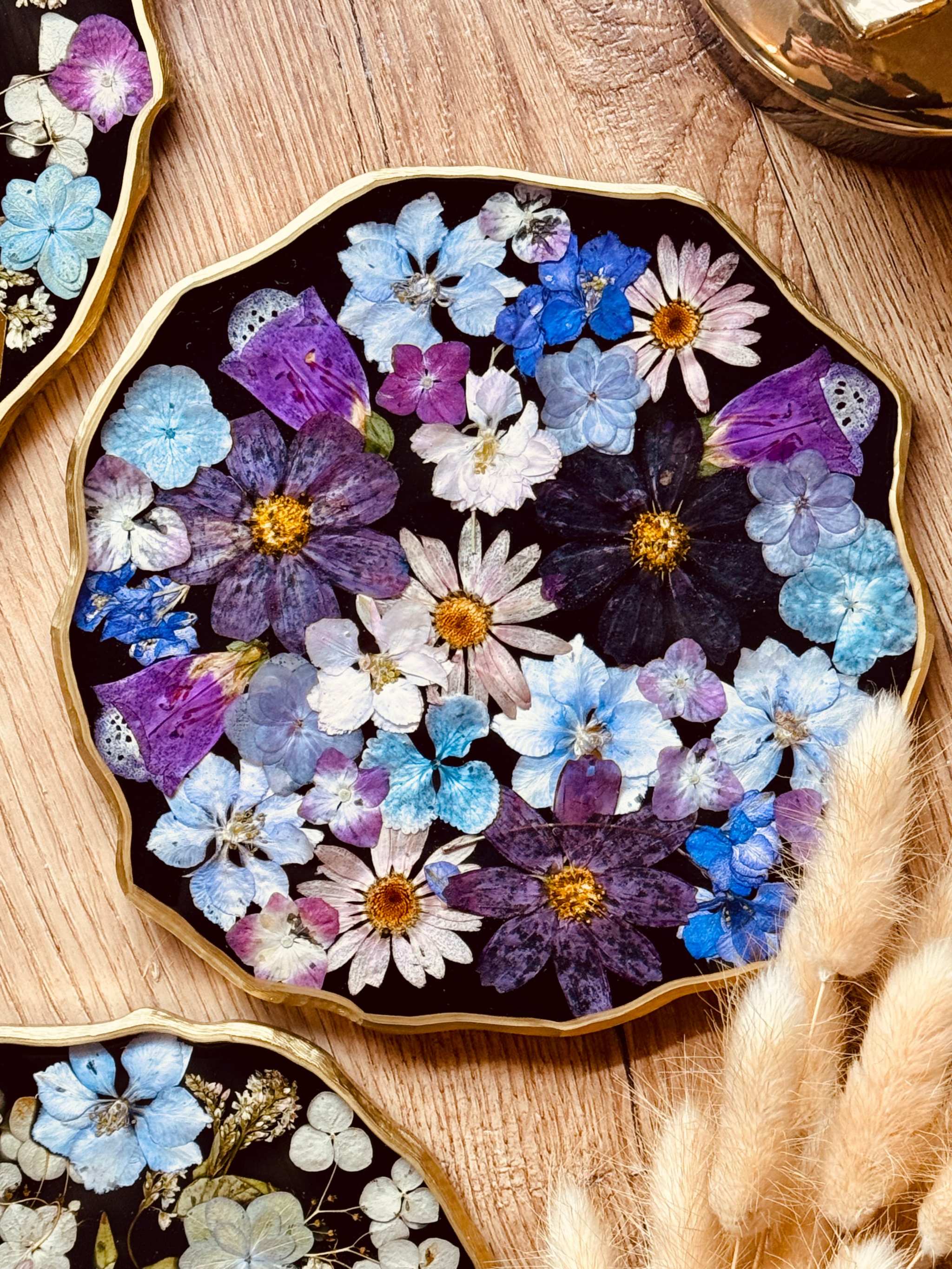 Handgemachtes Tablett aus Resin mit echten bunten Blumen und goldenen Details auf Holztisch