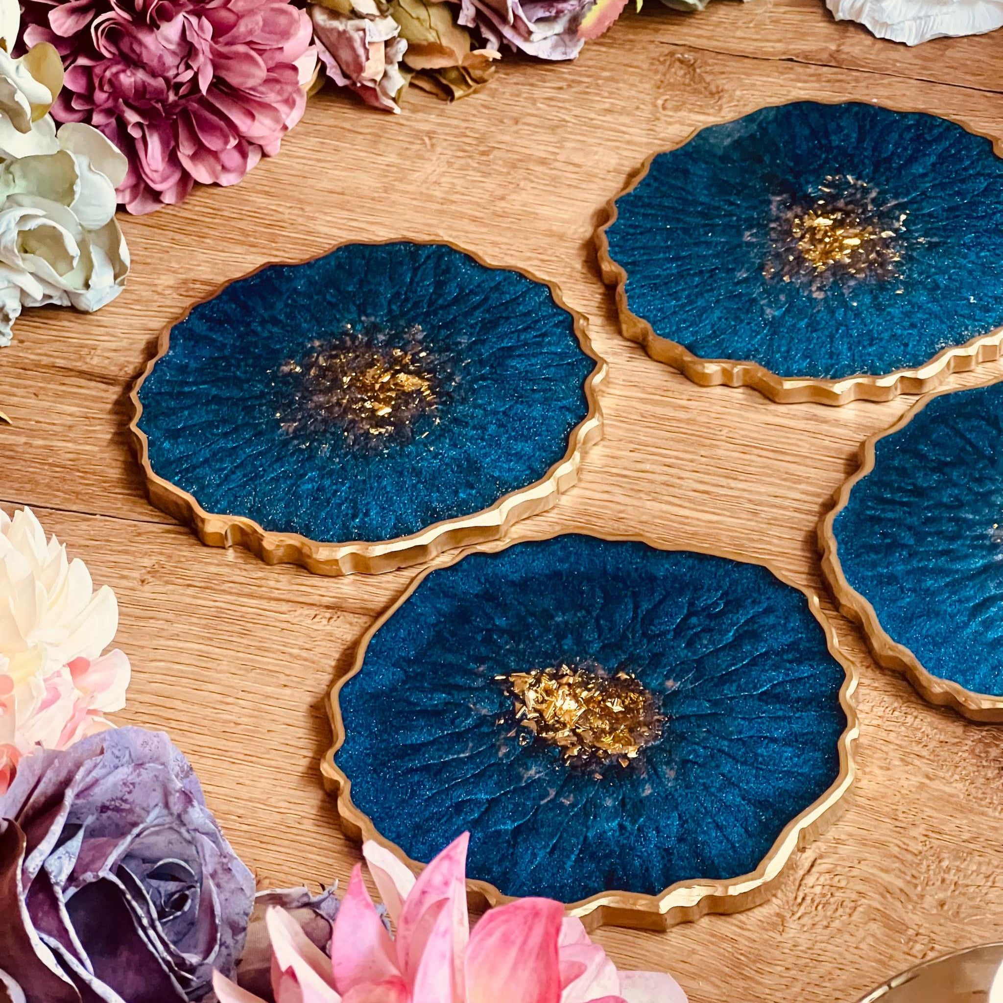 4 resin coasters in blue with gold