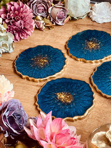 4 resin coasters in blue with gold