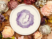 rundes handgemachtes Tablett aus Resin im violetten Geode Kristall Design auf Holztisch mit bunten Rosenblüten