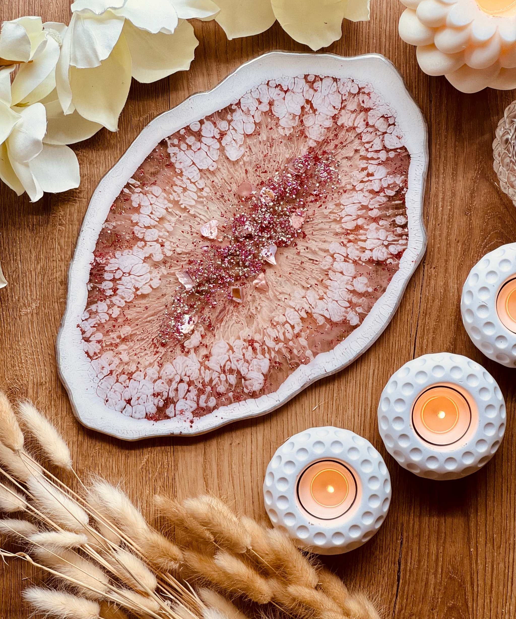 Tablett aus Resin in Rosa mit silbernen Details und organischer Form auf Holztisch mit Kerzen und Deko