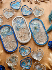 Handgemachte Schmuckschalen aus Resin in Blau und Silber mit eingegossenen Blumen in unterschiedlichen Herz- und Ovalformen