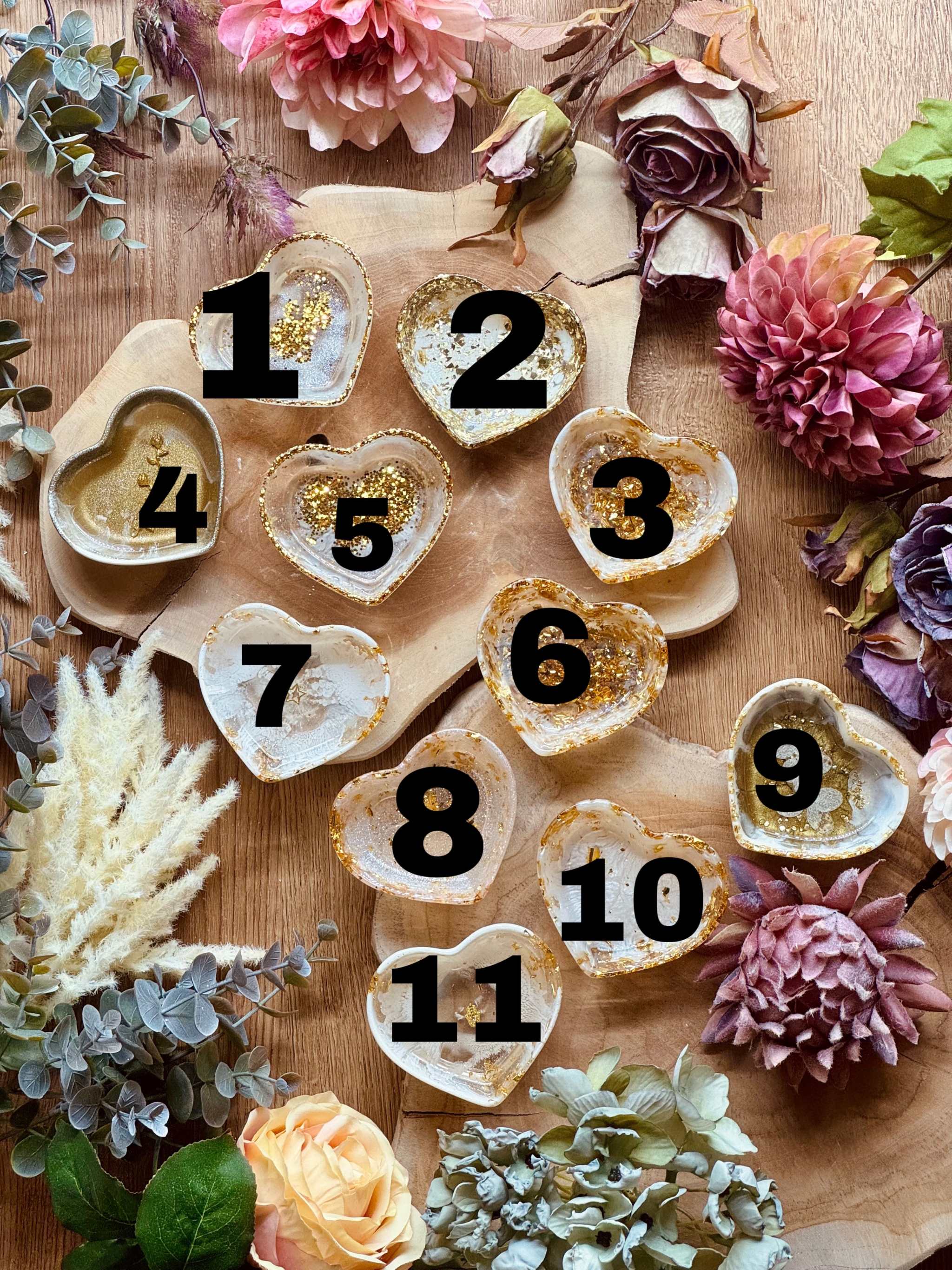 Herzförmige handgemachte Schmuckschalen aus weißem Resin mit goldenen Details dekoriert auf Holztisch mit Blumenarrangement