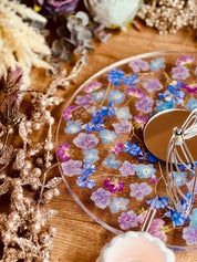 handgefertigte Resin Uhr mit getrockneten Blumen und Glitzer auf Holzoberfläche