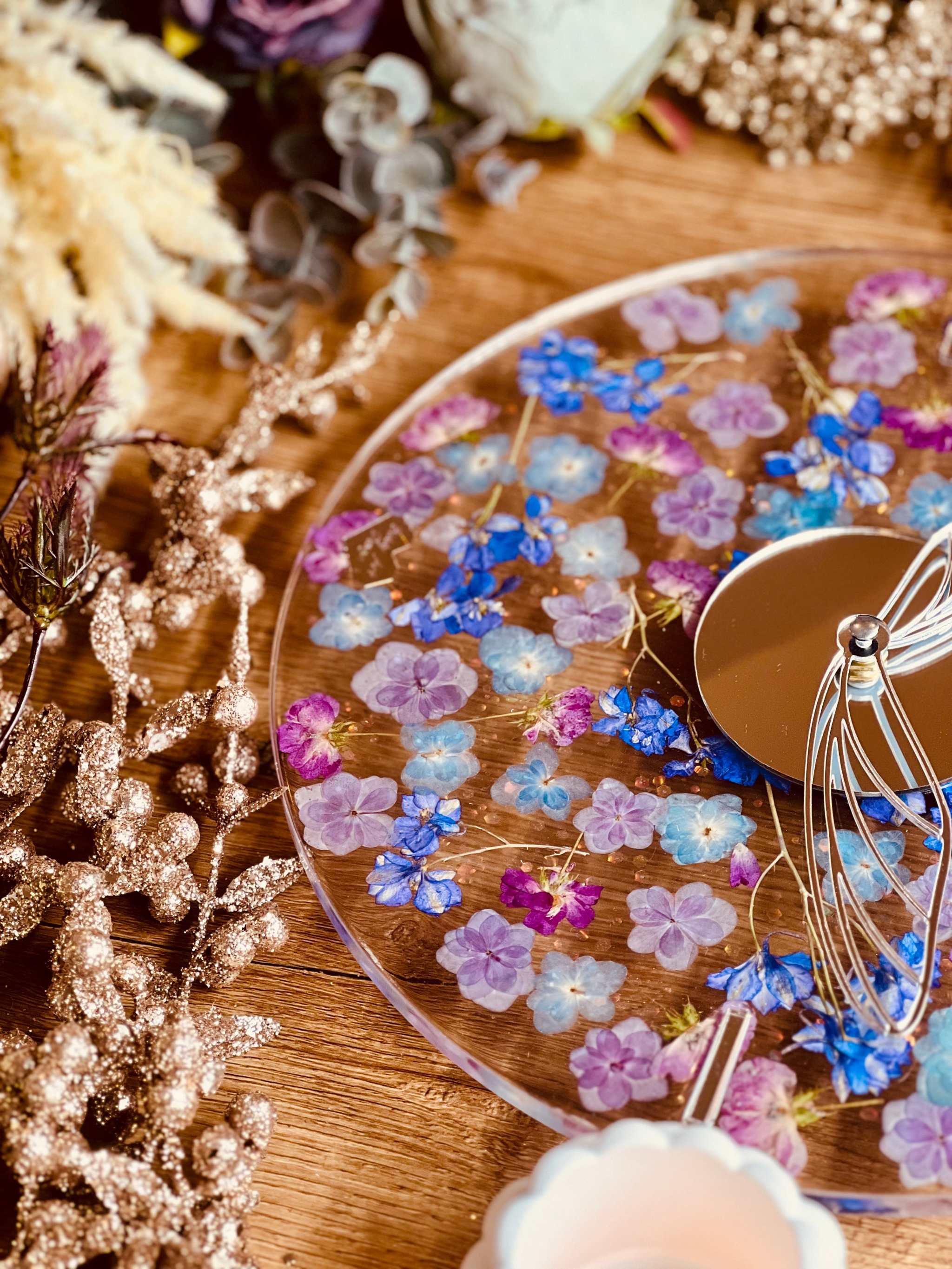 handgefertigte Resin Uhr mit getrockneten Blumen und Glitzer auf Holzoberfläche