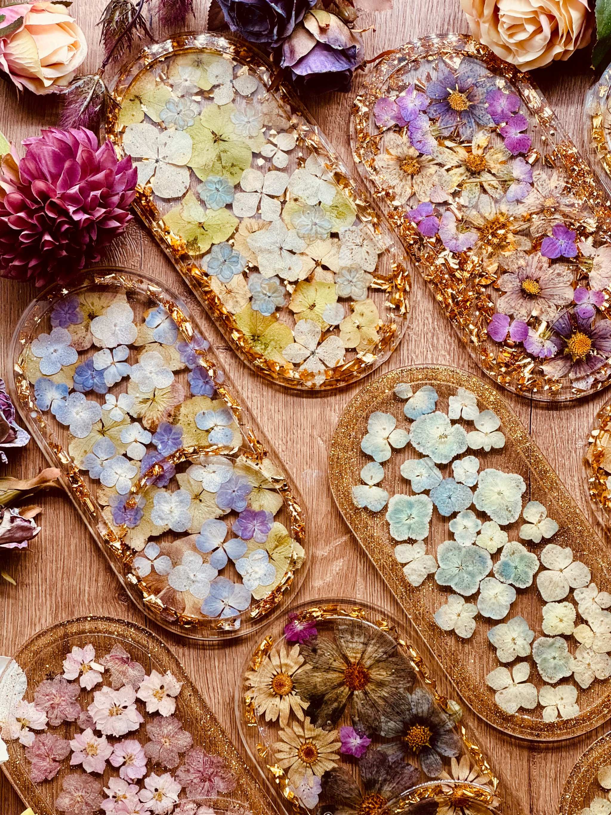 handgemachte schmuckschalen aus resin mit gold und getrockneten blüten in verschiedenen farben als einzigartige deko oder geschenk