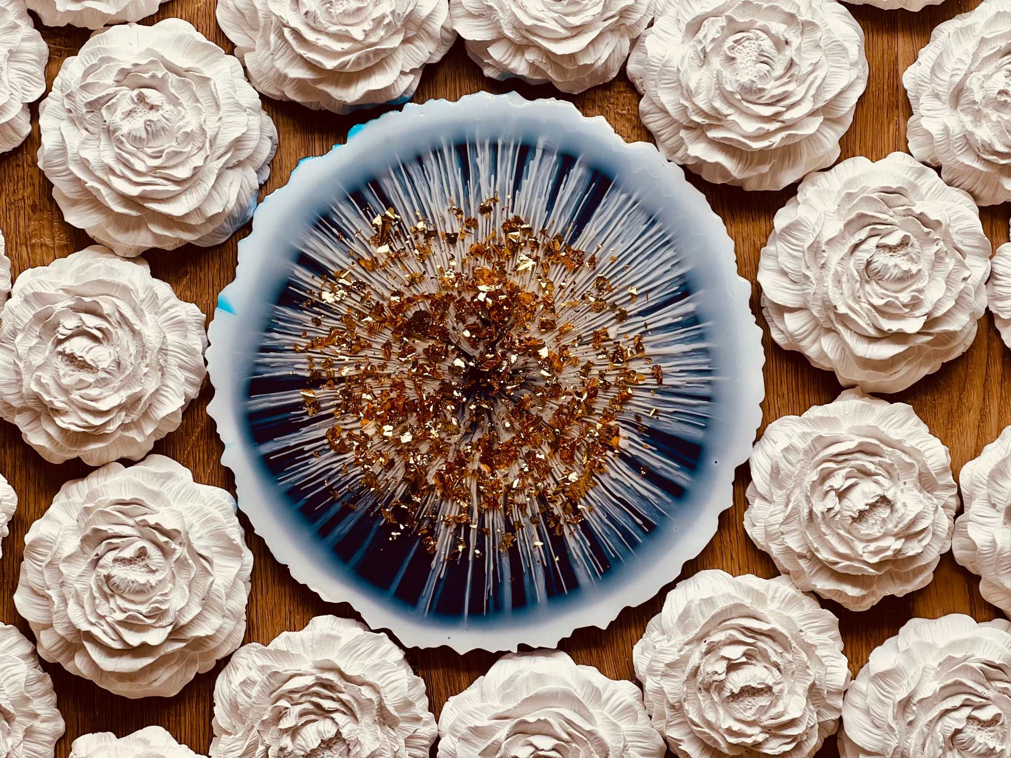 Handgemachtes blaues Resin Tablett mit goldenen Details und einzigartigem Design umgeben von weißen Rosen Dekorationen
