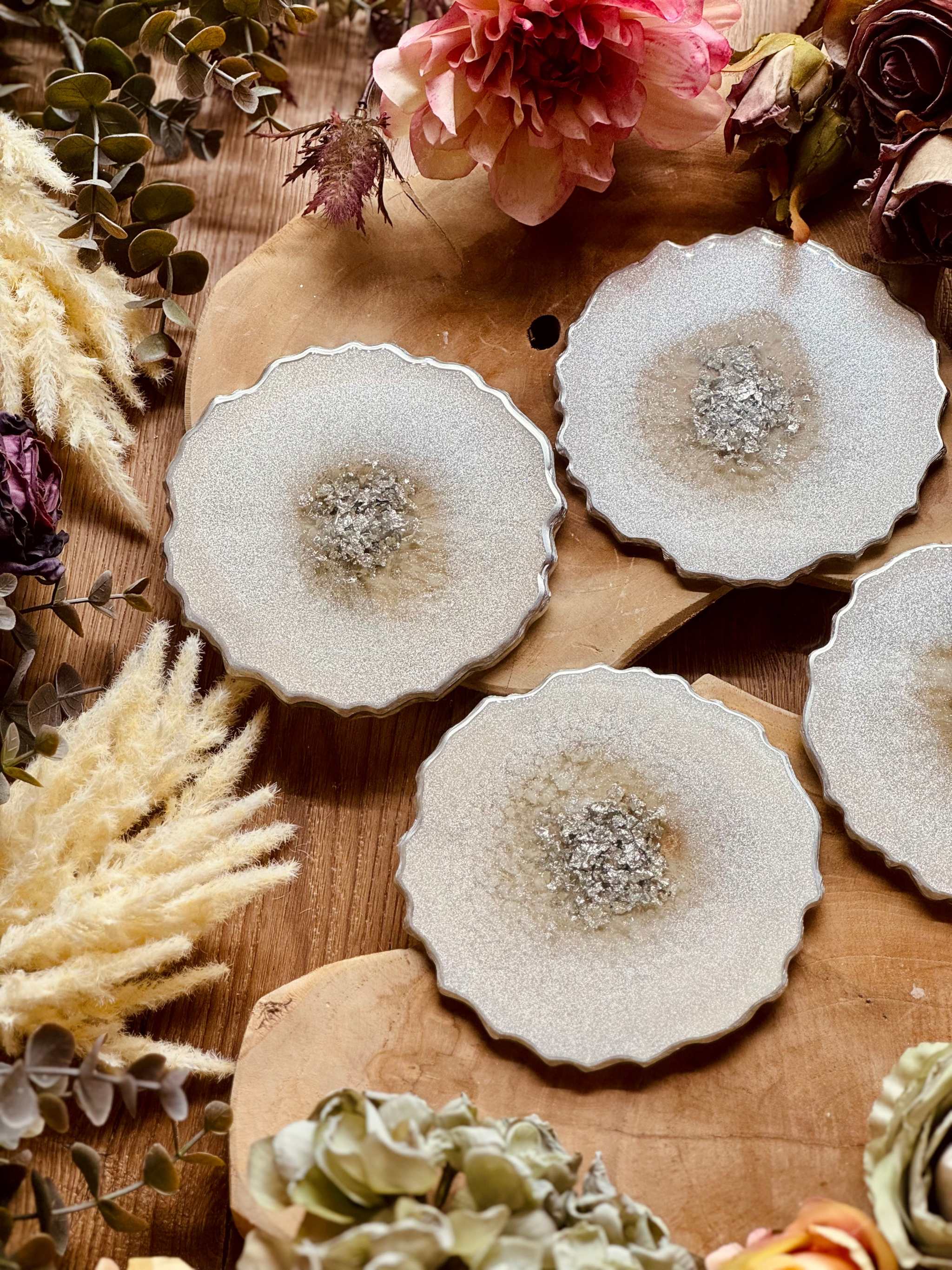 4 zeitlose weiße Untersetzer aus Resin mit silbernen Details auf Holztisch dekoriert