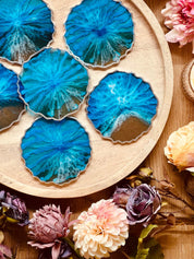 Handgemachte blaue Untersetzer aus Resin mit silbernen Details im Ocean Design, 6-teiliges Set auf einem Holztablett mit Blumen dekoriert