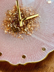 Nahaufnahme einer handgemachten Resin Uhr in Rosa mit goldenen Details und transparentem Zifferblattrand