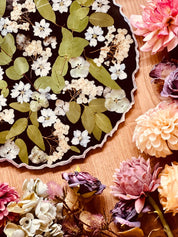 Schwarzes handgemachtes Resin Tablett mit Eukalyptus, Hortensien und silbernen Details auf Holztisch