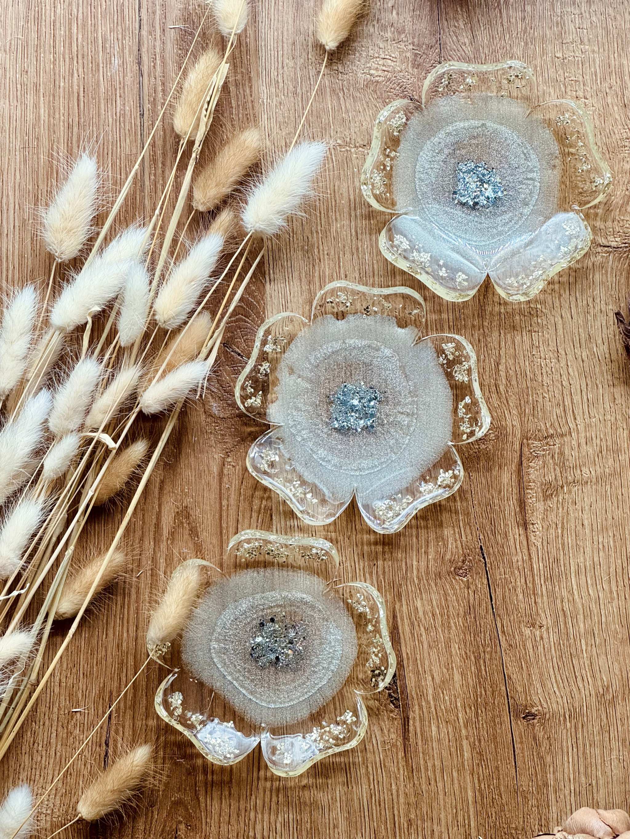 Handgemachte Schmuckschalen aus Resin in verschiedenen Farben mit silbernen Details als dekorative Ringschalen auf Holztisch