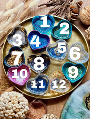 Bunte handgemachte Schmuckschalen aus Resin mit goldenen Details in Herzform auf goldfarbenem Tablett