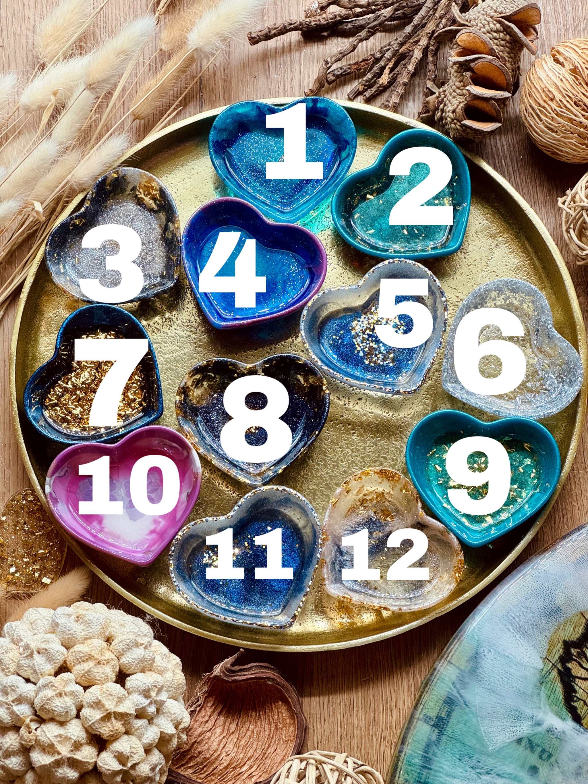 Bunte handgemachte Schmuckschalen aus Resin mit goldenen Details in Herzform auf goldfarbenem Tablett