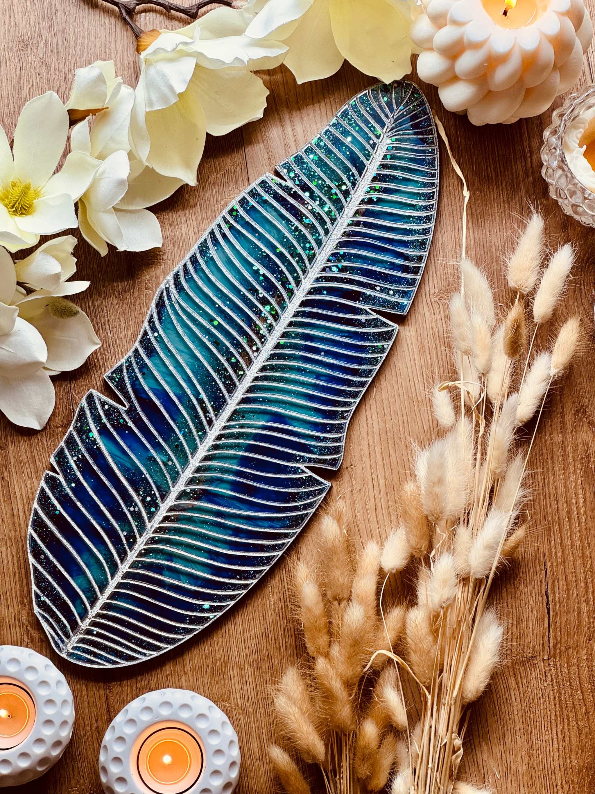 Tablett aus Resin in türkis mit silbernen Blätterdetails, handgemacht und dekorativ auf Holztisch mit Kerzen und Blumen arrangiert