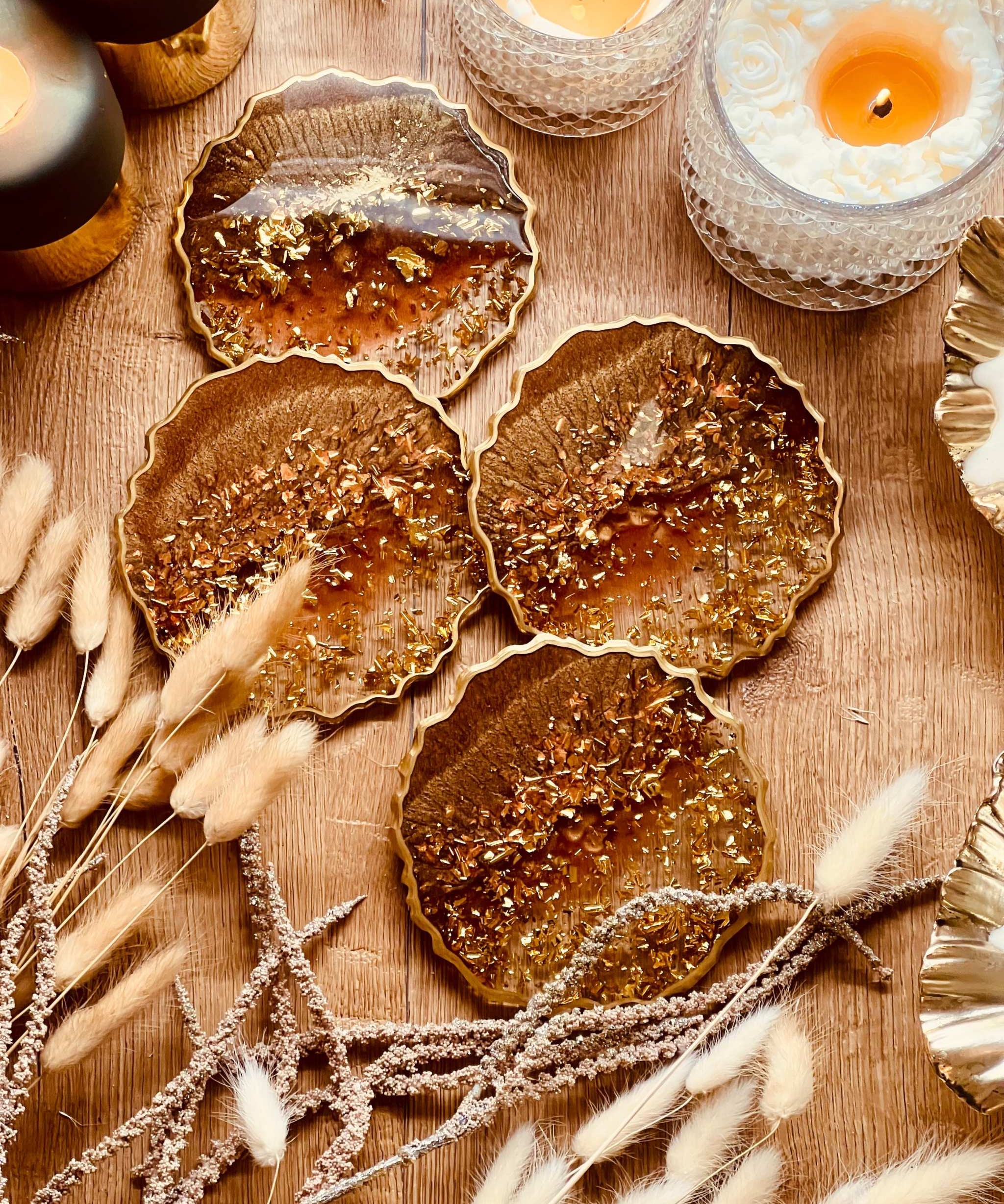 4 handgemachte braune Resin Untersetzer mit goldenen Details als dekoratives Set auf Holztisch
