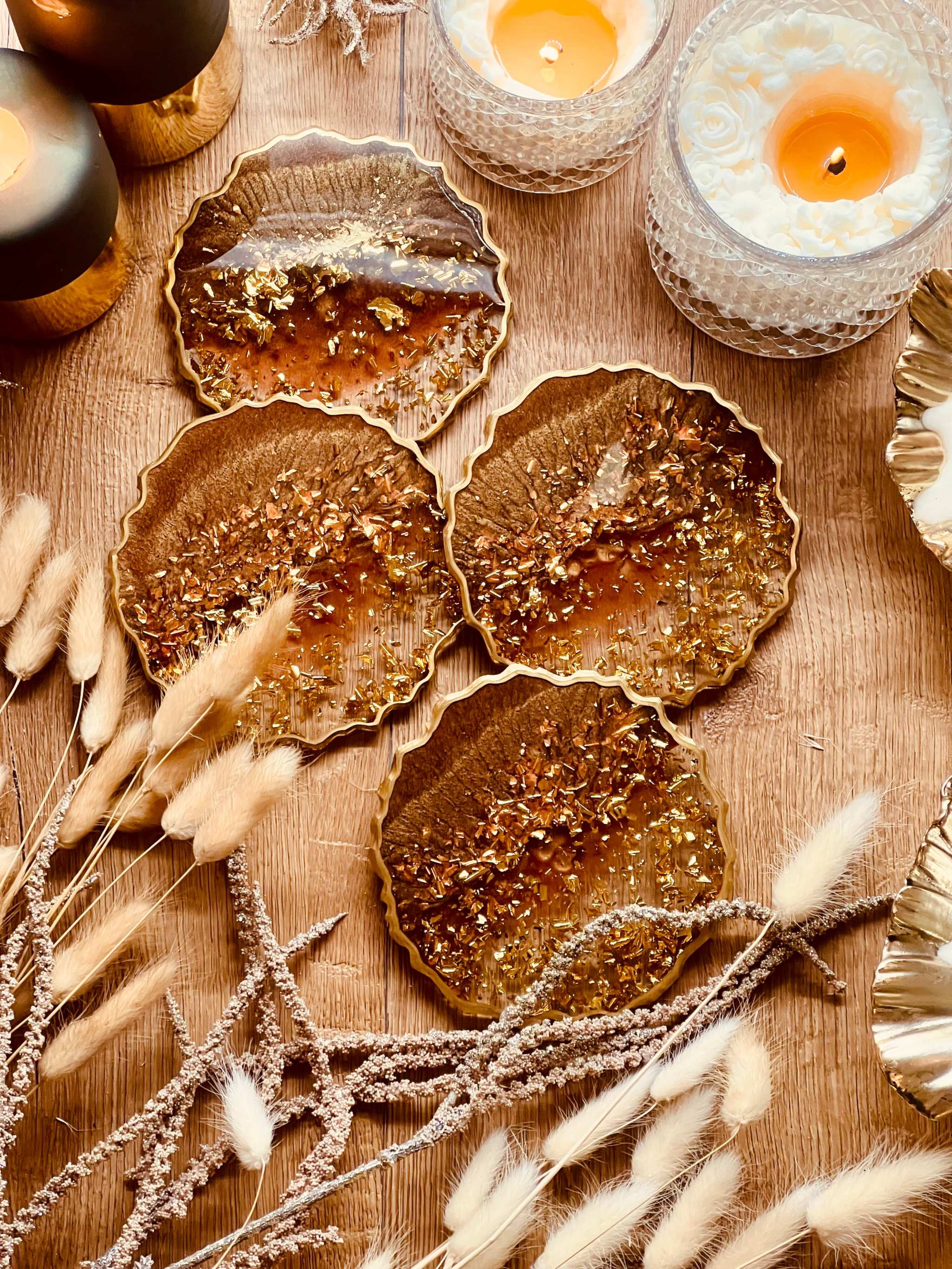 4 handgemachte braune Resin Untersetzer mit goldenen Details als dekoratives Set auf Holztisch
