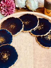 6 handgemachte Untersetzer aus blauem Resin mit goldenen Details als dekoratives Set auf Holzplatte