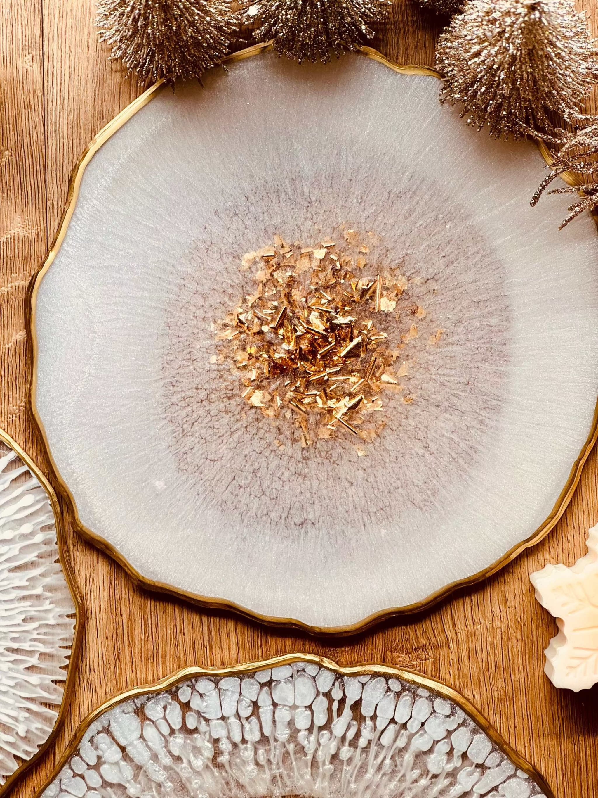 weisses handgemachtes Resin Tablett mit goldenen Details und unregelmäßigem Rand auf Holztisch