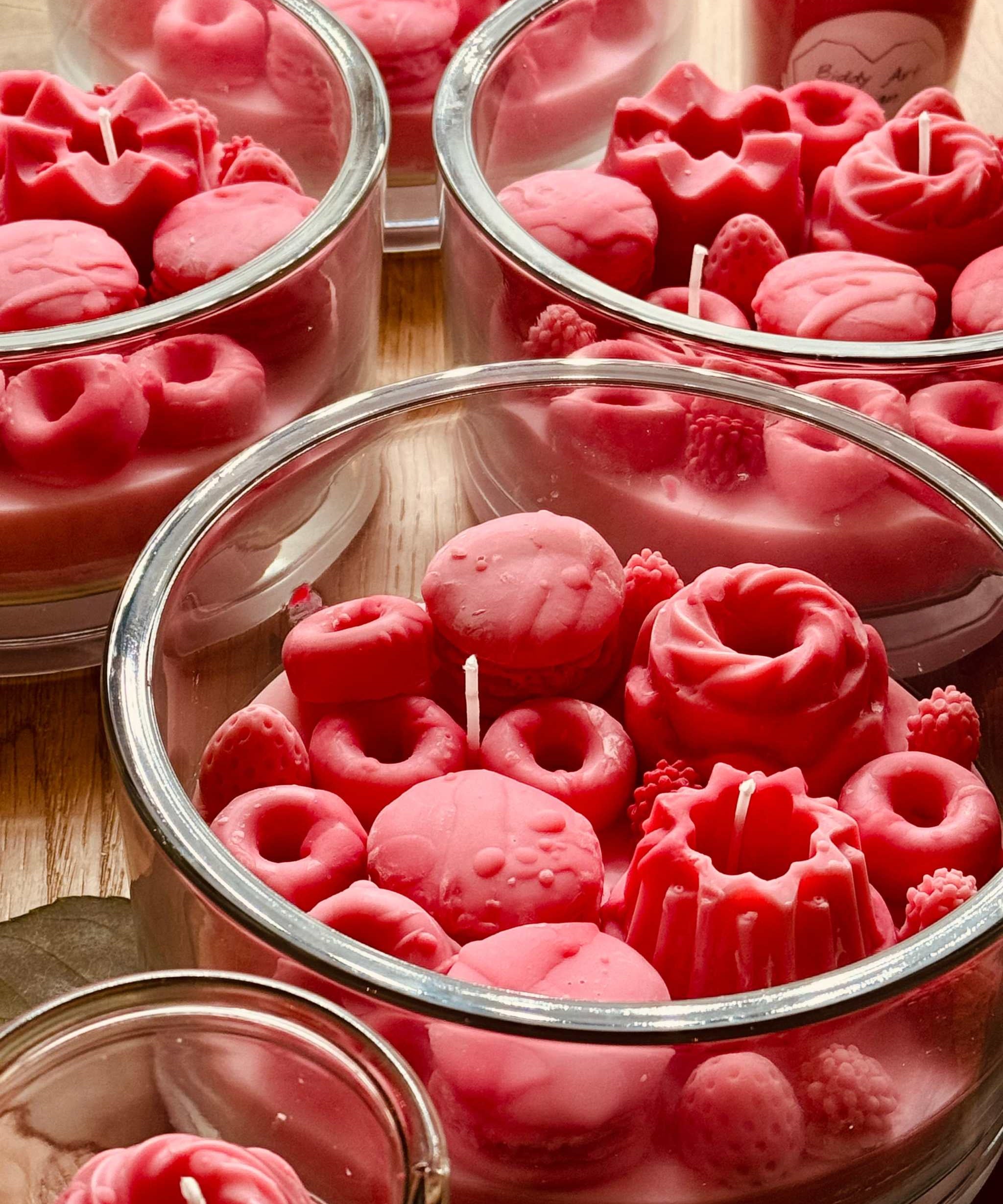 Duftkerze in Rosa und Pink im Glas, verziert mit Wachsbonbons und Süßigkeiten – ein verspieltes Geschenk und dekorative Bereicherung