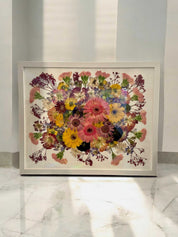 Konservierter Brautstrauß im Bilderrahmen mit goldener Umrandung und eleganter floraler Anordnung