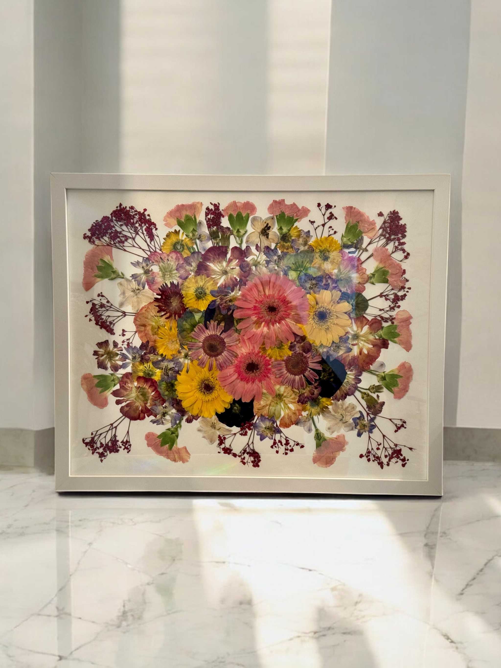 Konservierter Brautstrauß im Bilderrahmen mit goldener Umrandung und eleganter floraler Anordnung