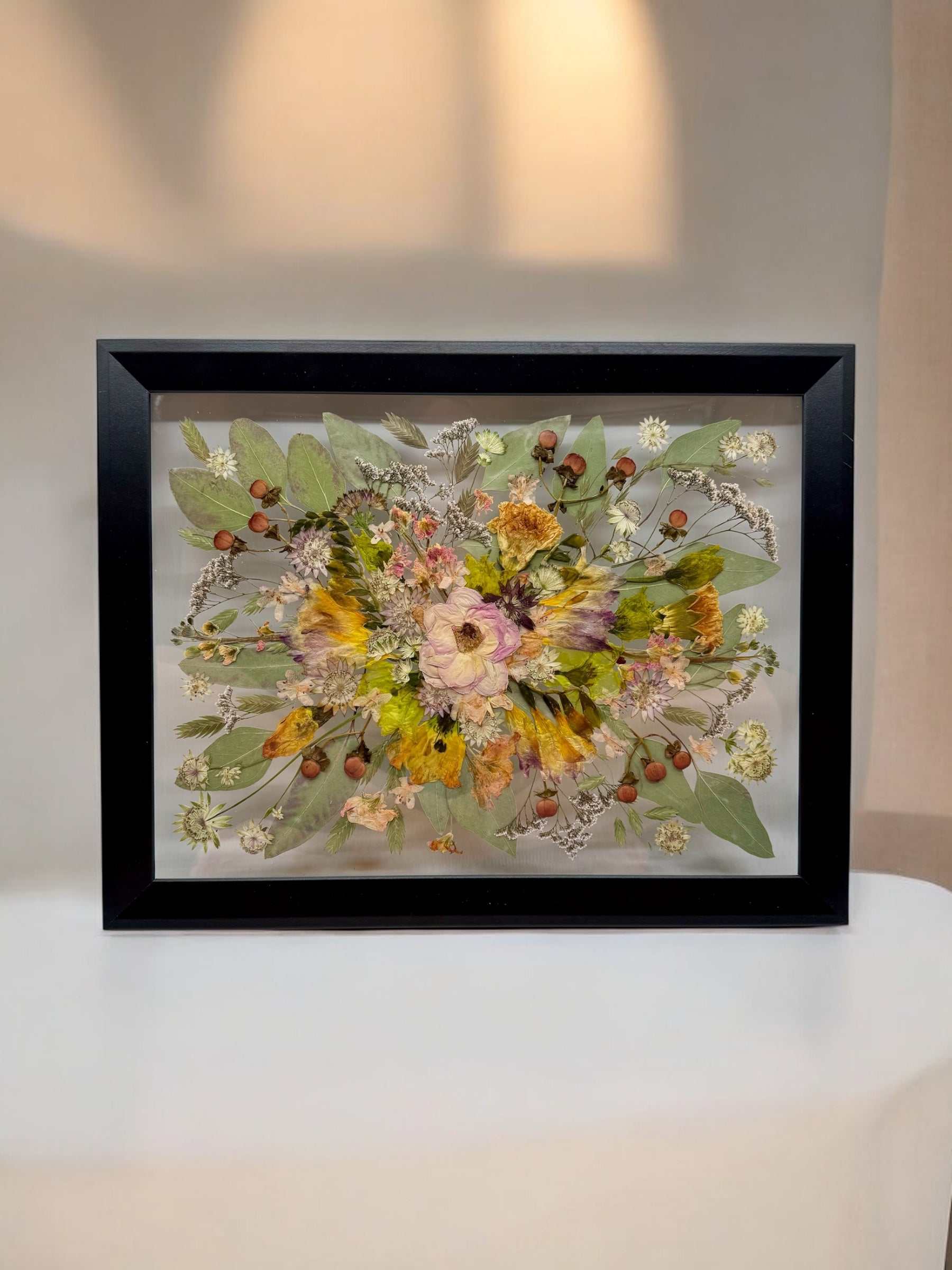 Konservierter Brautstrauß im Bilderrahmen in Weiß, liebevoll arrangierte Hochzeitsblumen aus der Brautstrauß Konservierung