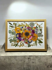 Nahaufnahme eines konservierten Brautstraußes im Bilderrahmen mit Rosen und Hortensien