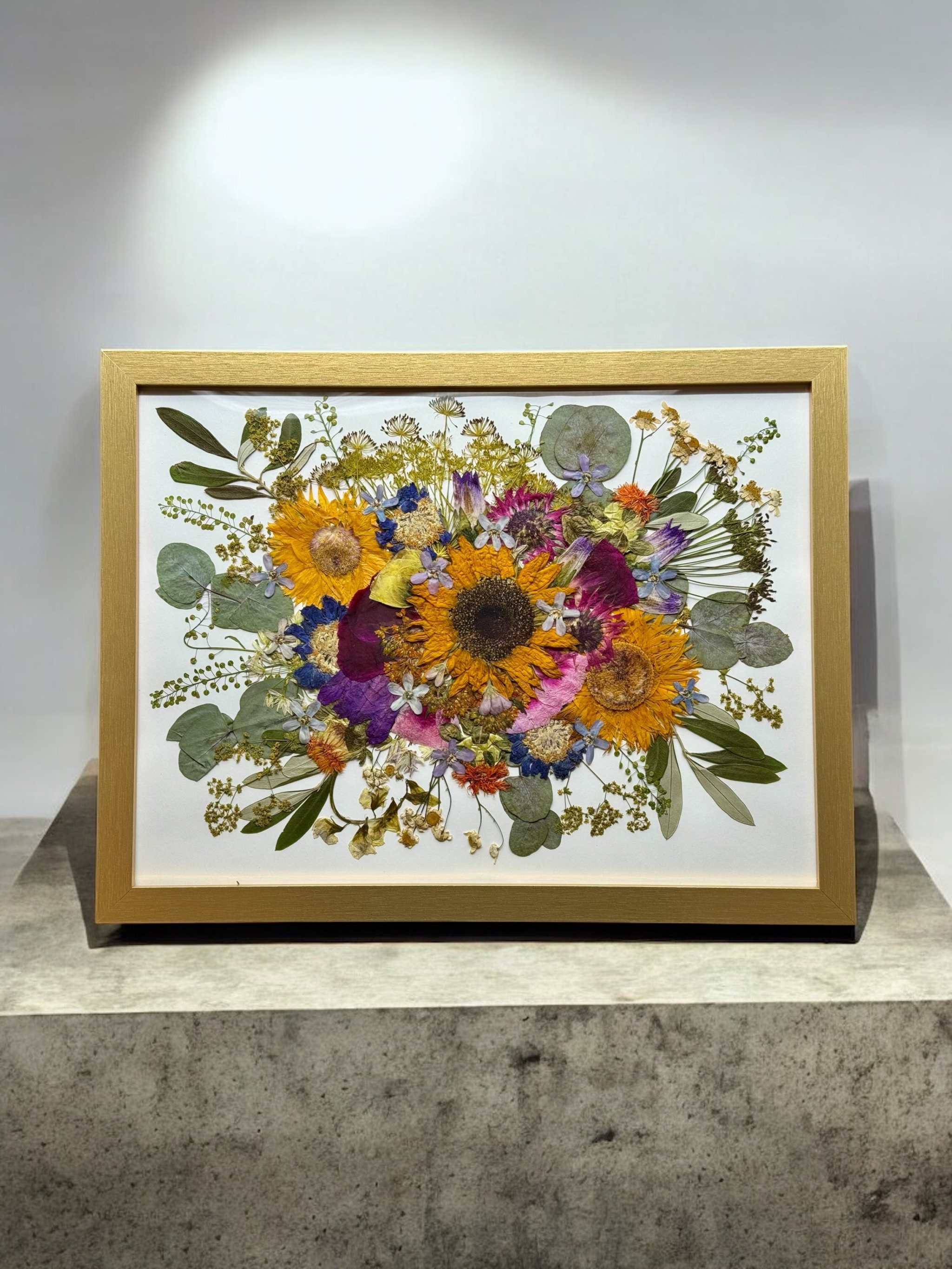 Nahaufnahme eines konservierten Brautstraußes im Bilderrahmen mit Rosen und Hortensien