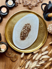 weißes handgemachtes Resin Tablett mit goldenen Details auf goldenem Untersetzer dekorativ arrangiert
