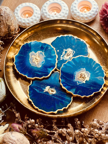 4 resin coasters in blue with gold