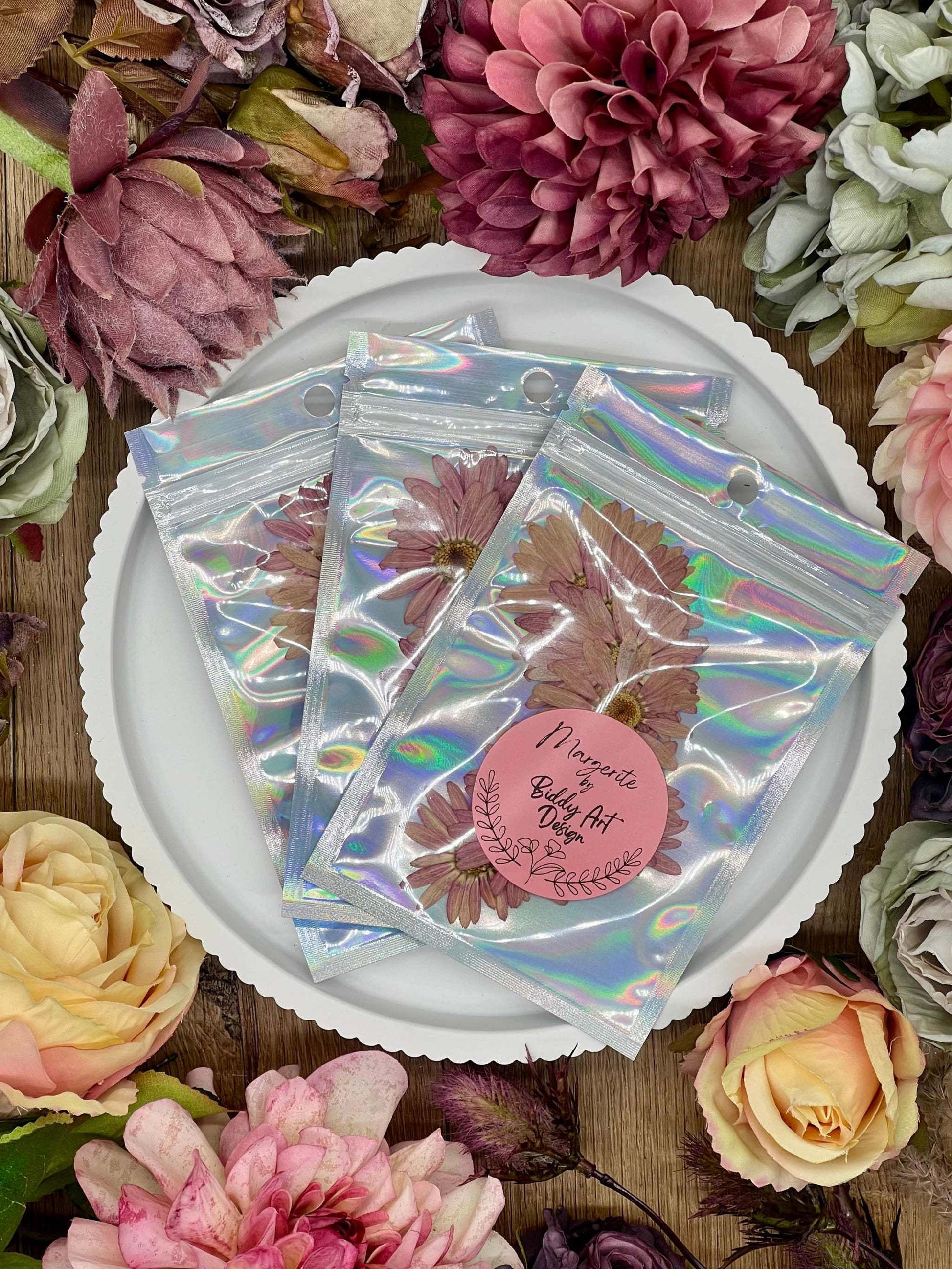 Elegante Verpackung mit handverlesenen, getrockneten Blumen und Blüten, bereit für kreative Projekte und Resin Art.
Wunderschön präsentierte Blumen in dekorativer Verpackung, ideal für Bastelprojekte, Hochzeitsdekoration oder als Geschenk.