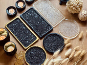 Tablett Set aus Resin mit schwarzer und klarer druzy Oberfläche in rechteckiger und runder Form als Deko auf Holztisch