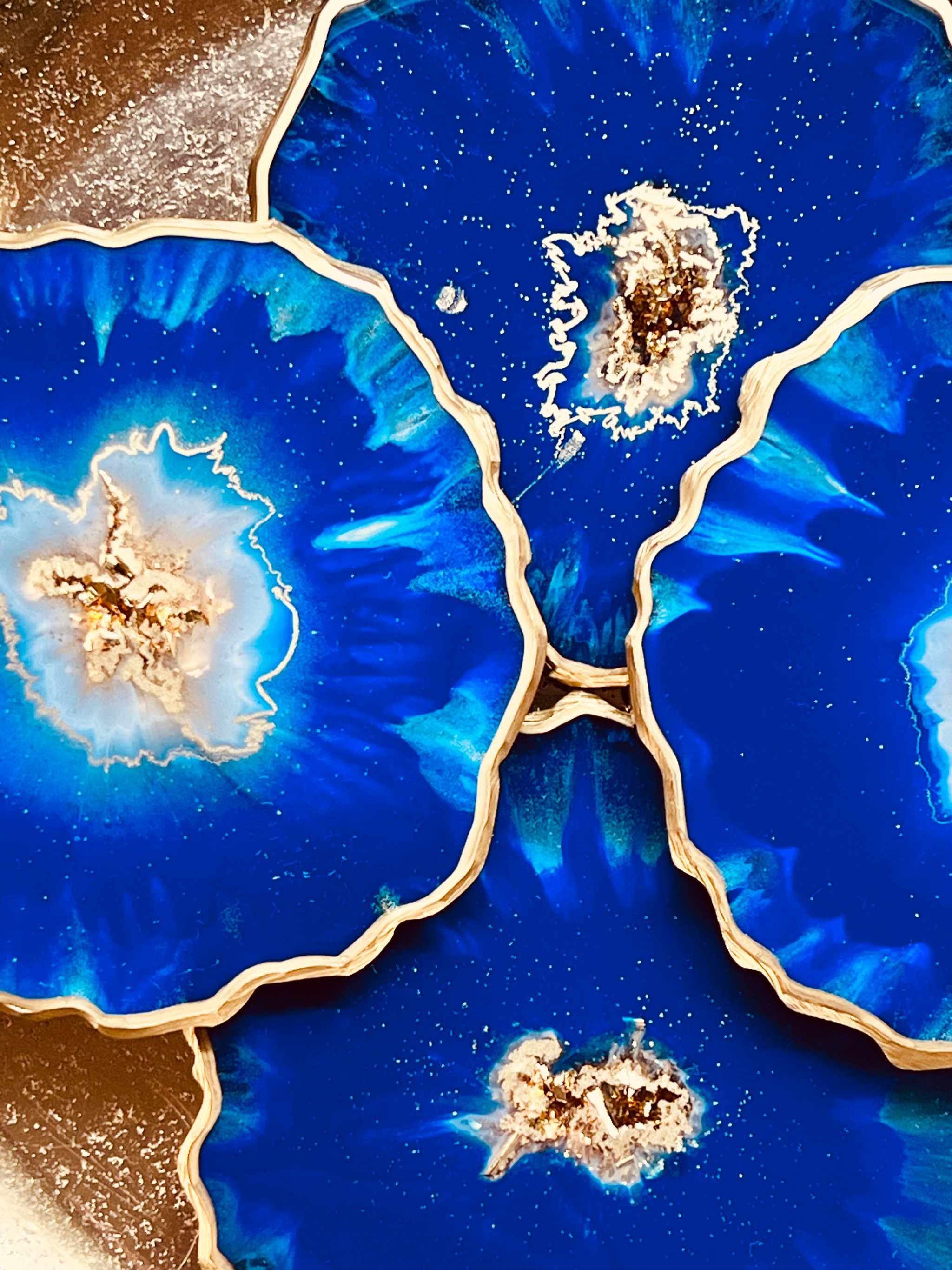 4 resin coasters in blue with gold
