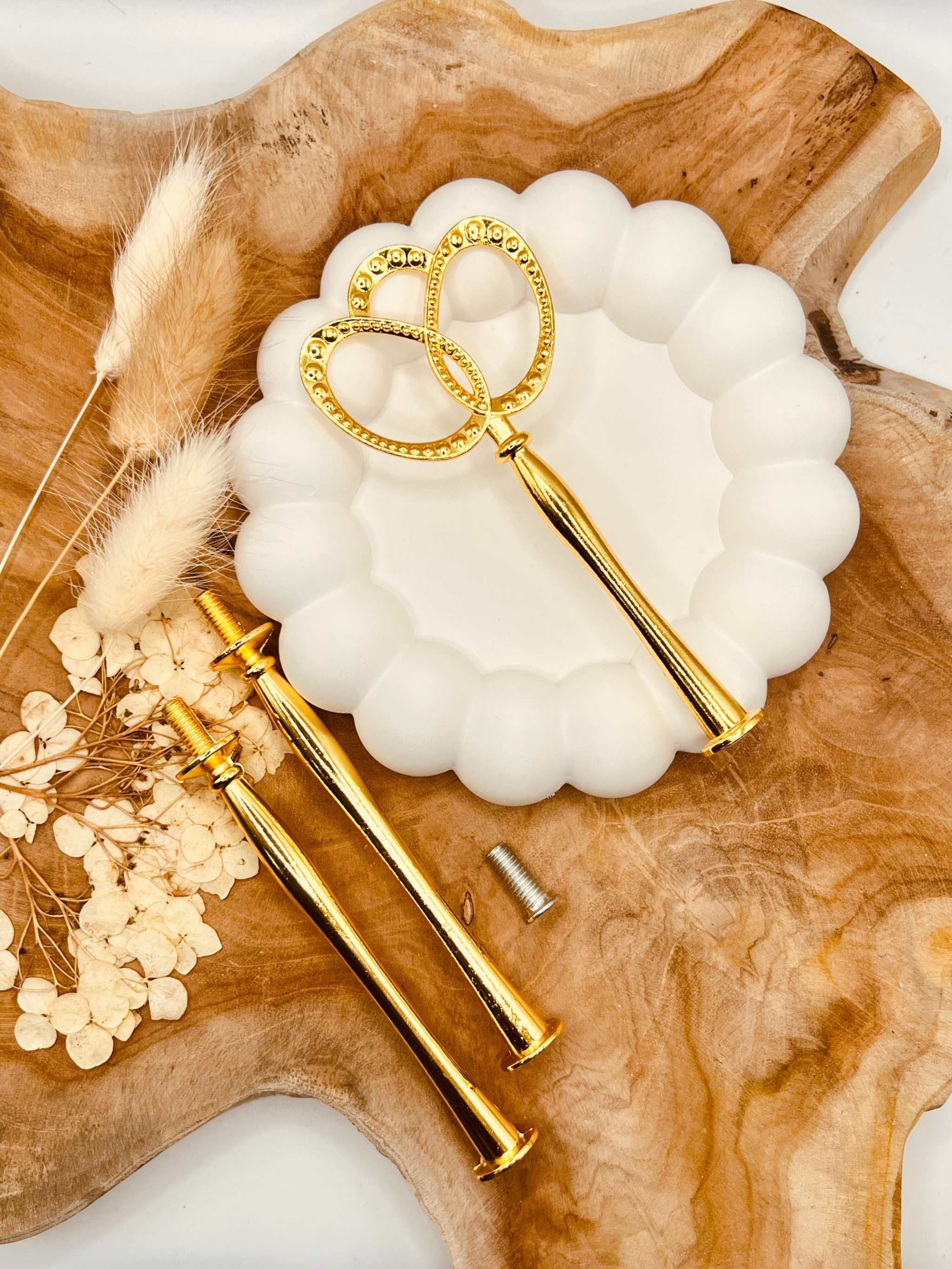 Detailansicht der goldfarbenen Etagerenstange mit Blasenring-Motiv