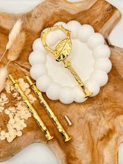 Detailansicht der goldfarbenen Etagerenstange mit Blatt-Verzierung