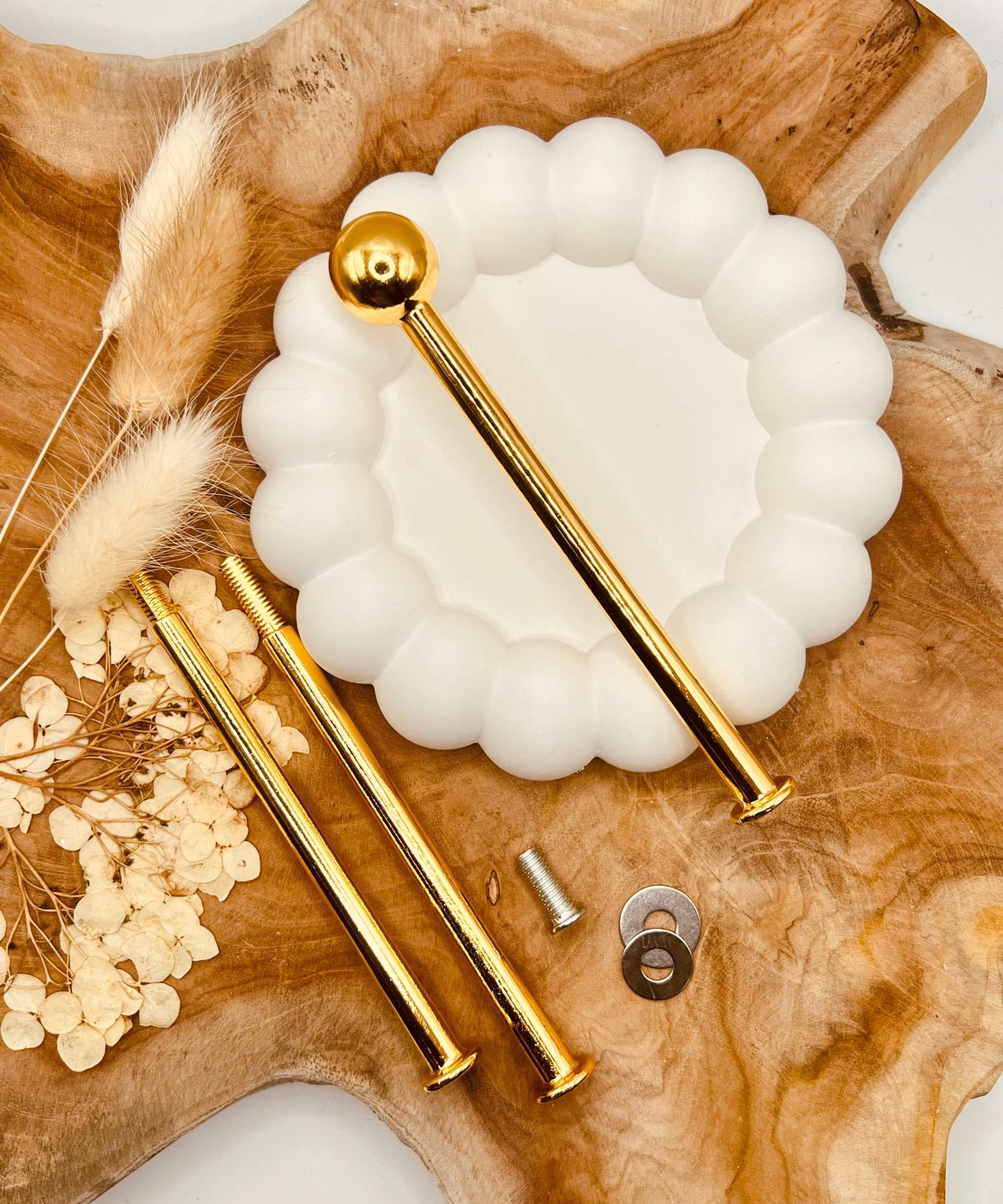 Detailansicht der goldfarbenen Etagerenstange mit “Bullet”-Motiv
