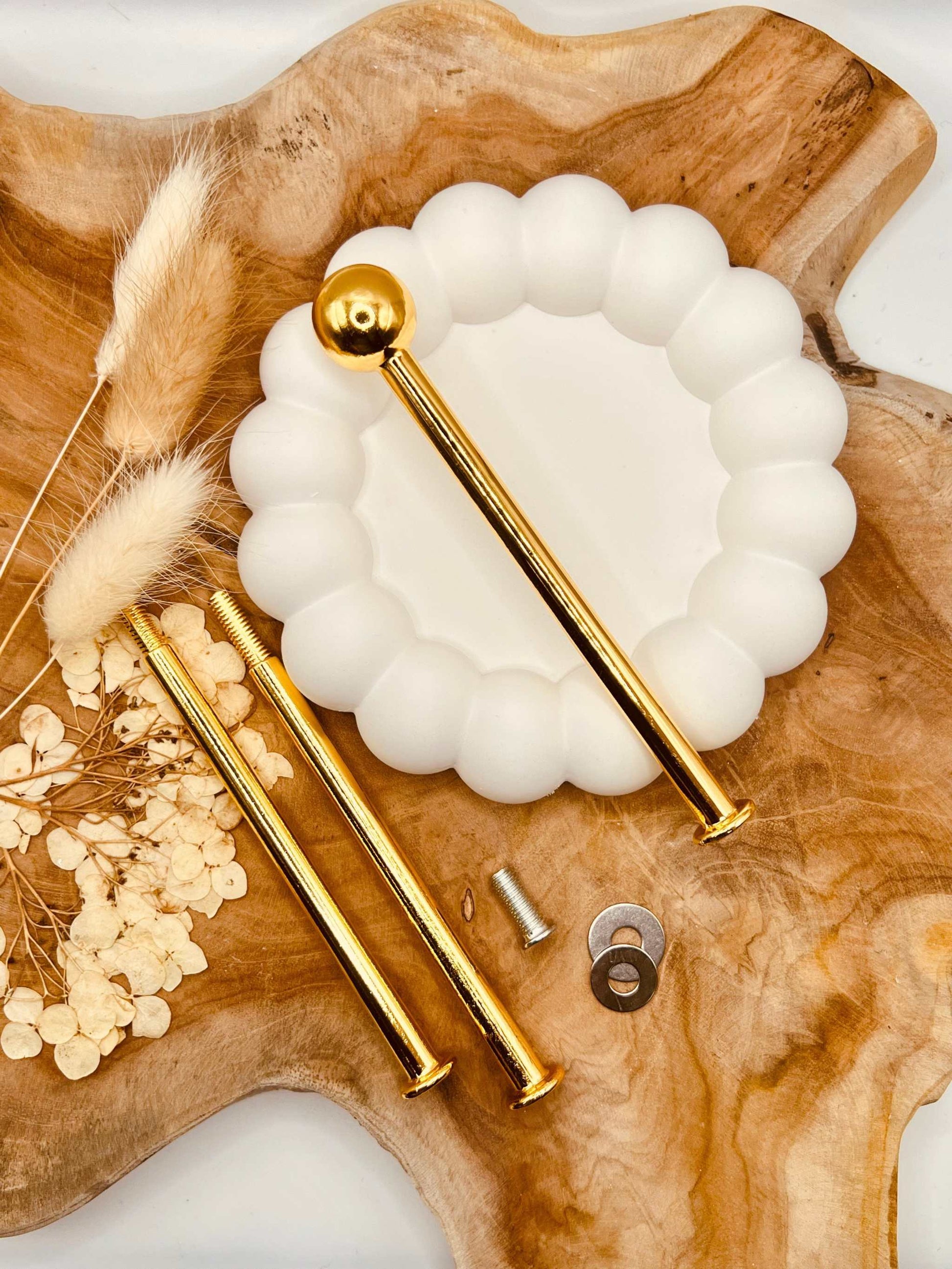 Detailansicht der goldfarbenen Etagerenstange mit “Bullet”-Motiv