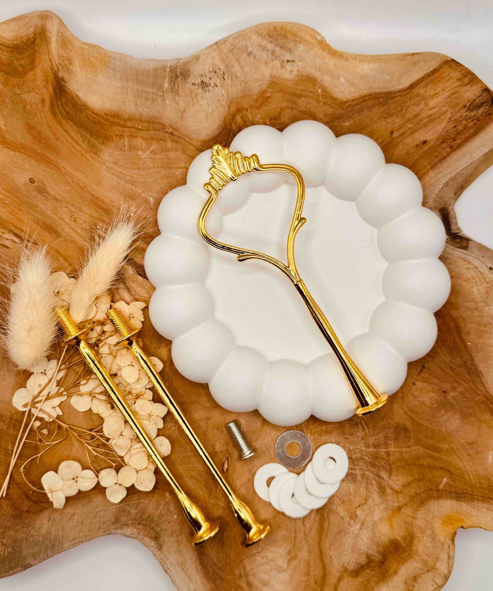 Detailansicht der goldfarbenen Etagerenstange mit traditionellem Kronen-Motiv