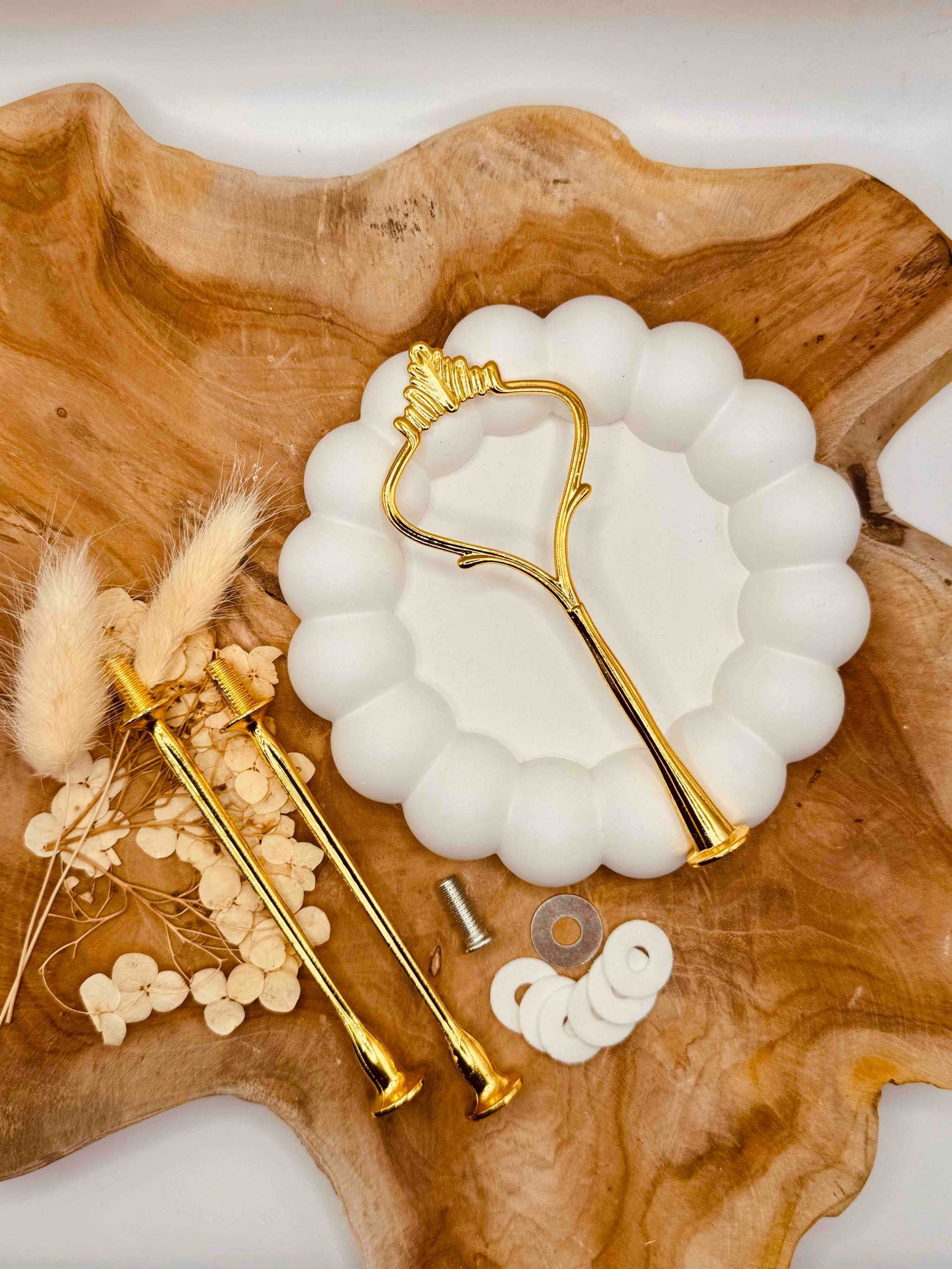 Detailansicht der goldfarbenen Etagerenstange mit traditionellem Kronen-Motiv