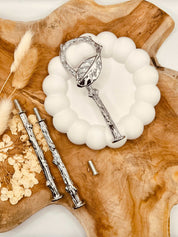 Detailansicht der silberfarbenen Etagerenstange mit Blattmotiv