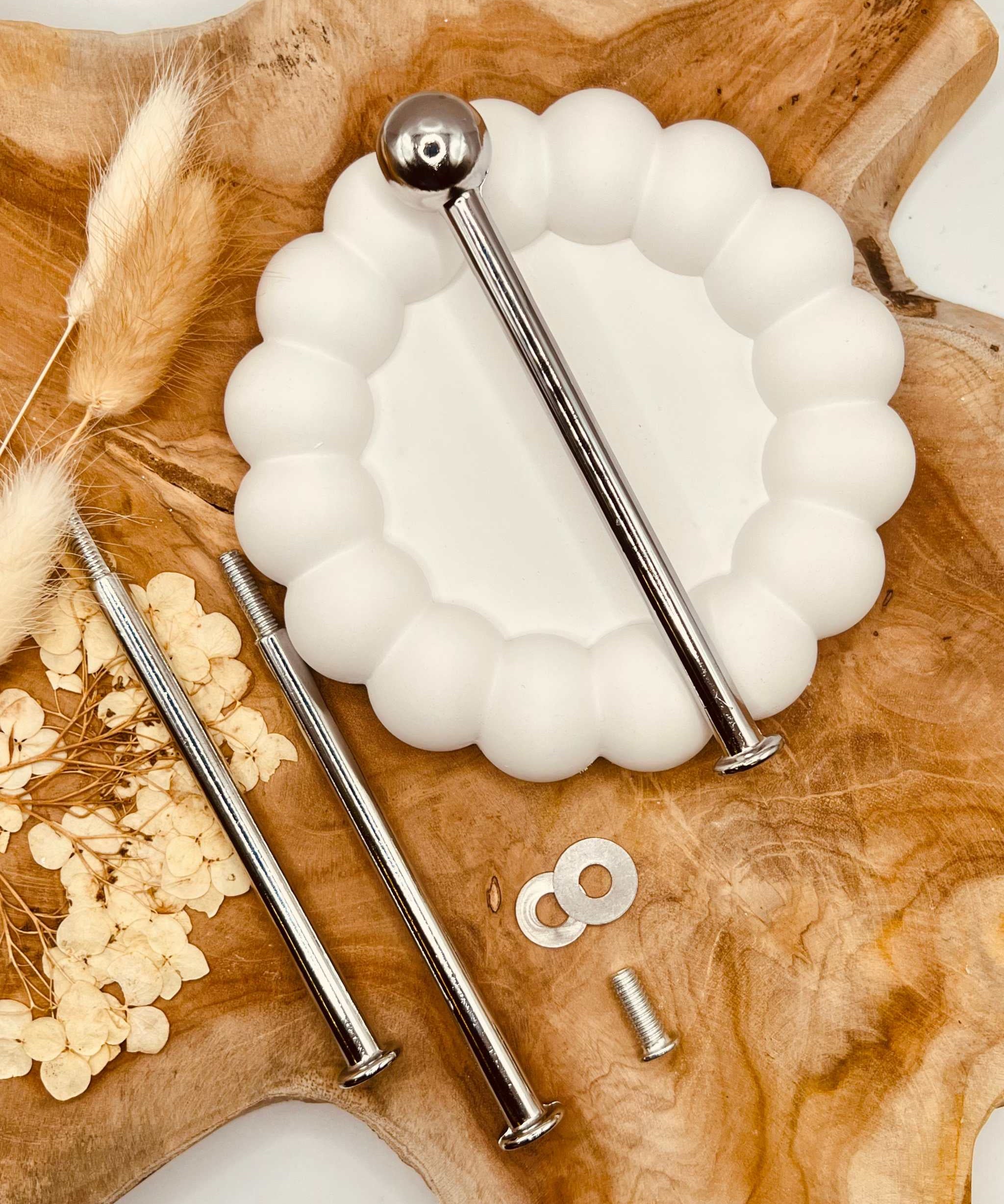 Detailansicht der silberfarbenen Etagerenstange mit “Bullet”-Motiv